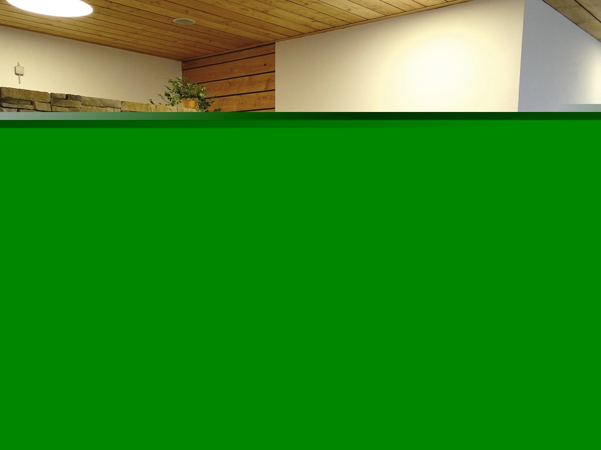 Ruheraum mit Liegestühlen, Bademänteln an der Wand und Natursteinwand.