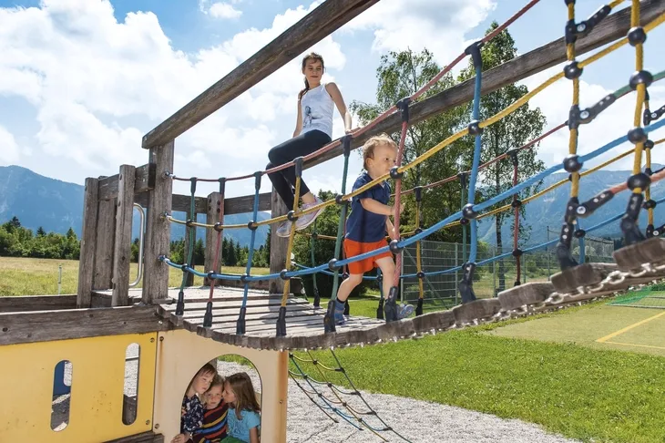 Kinder spielen auf einem Klettergerüst im Freien.