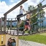 Kinder spielen auf einem Klettergerüst im Freien.