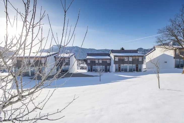 Winterliche Landschaft mit schneebedeckten Häusern und Bäumen in Inzell.