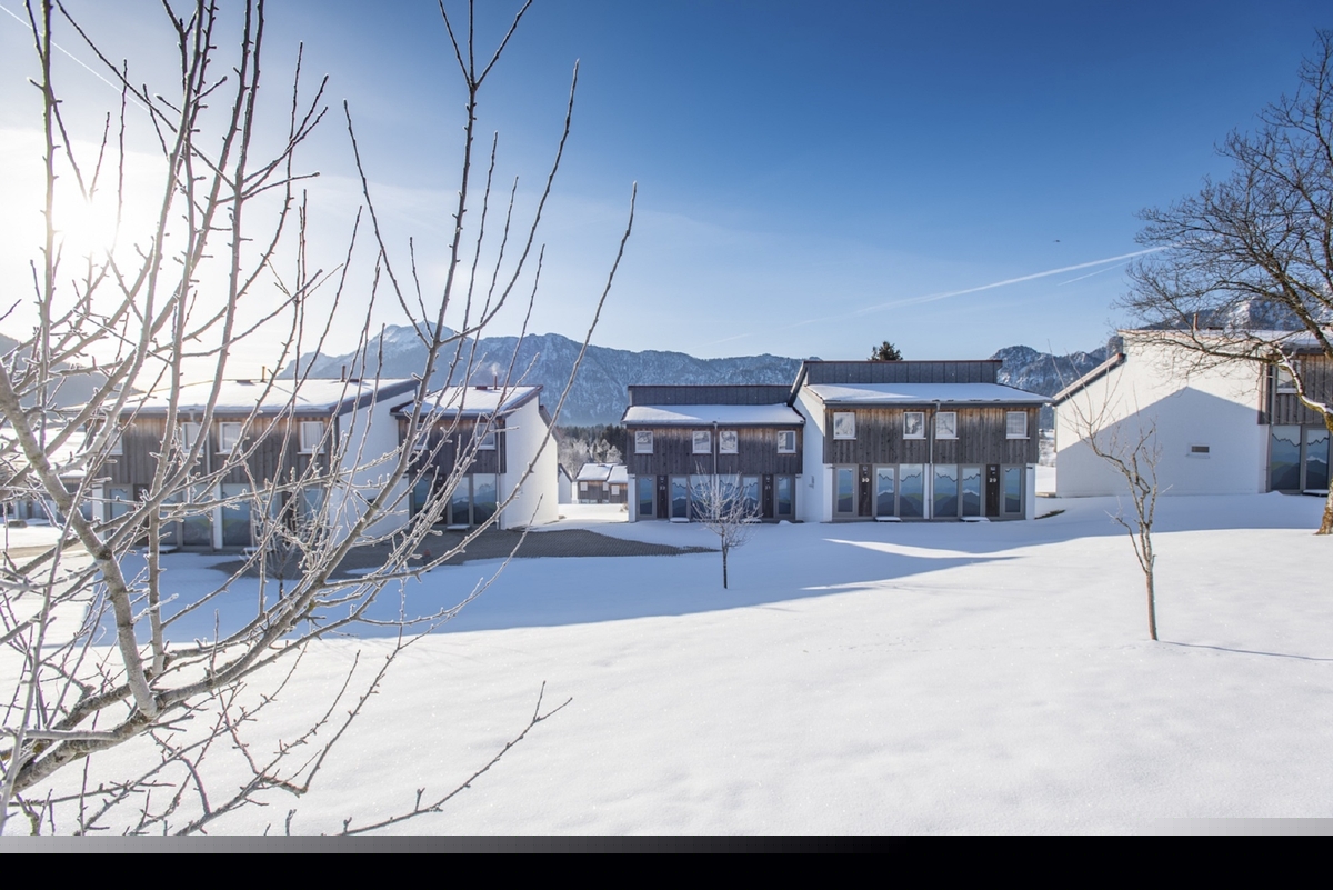 Winterliche Landschaft mit schneebedeckten Häusern und Bäumen in Inzell.