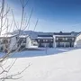 Winterliche Landschaft mit schneebedeckten Häusern und Bäumen in Inzell.