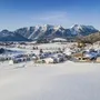 Verschneite Landschaft mit Bergpanorama und Dorf im Winter in Inzell.
