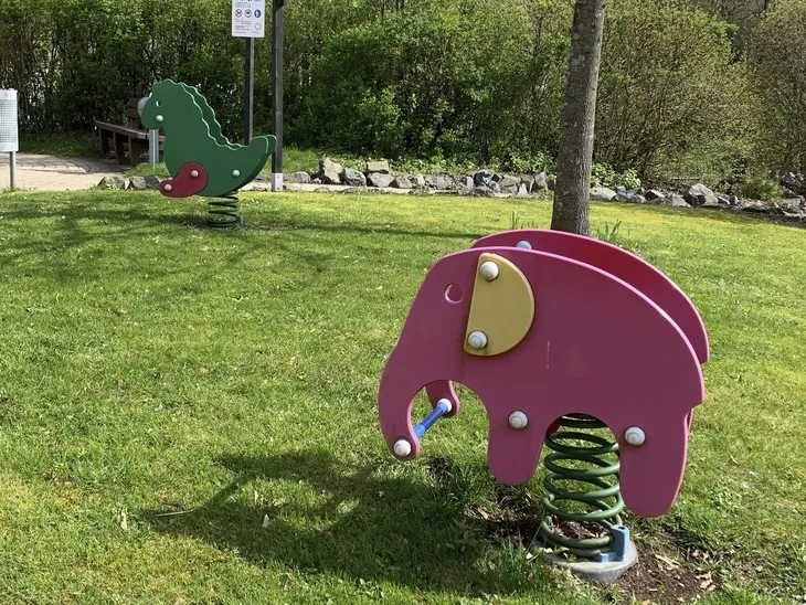 Zwei bunte Wipptiere auf einer grünen Wiese im Garten der Ferienanlage Braunlage.