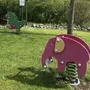Zwei bunte Wipptiere auf einer grünen Wiese im Garten der Ferienanlage Braunlage.