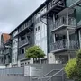 Eingangsbereich mit Treppe zu einem mehrstöckigen, modernen Gebäude der Ferienanlage Braunlage mit Balkonen.