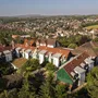 Luftaufnahme einer Wohnsiedlung am Rande einer Stadt mit bewaldeter Landschaft.