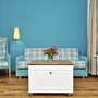 Wohnzimmer mit blauer Wand, kariertem Sofa, Sessel, Tisch und Blumenstrauß in der Ferienanlage List auf Sylt.