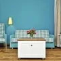 Wohnzimmer mit blauer Wand, kariertem Sofa, Sessel, Tisch und Blumenstrauß in der Ferienanlage List auf Sylt.
