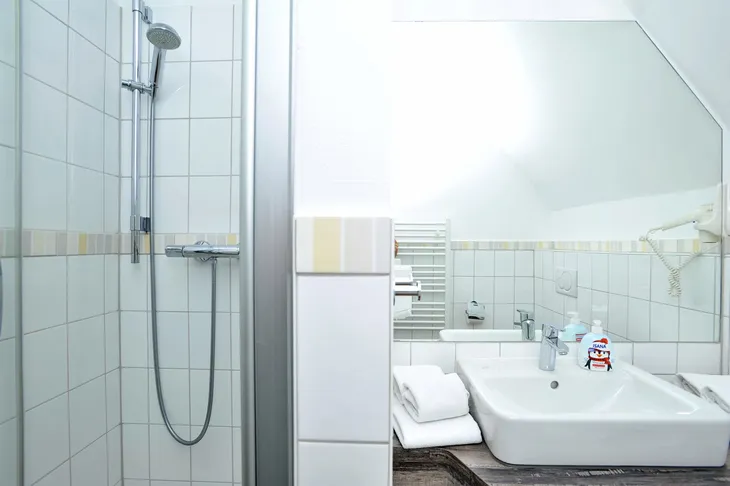 Modernes Badezimmer mit Dusche und Waschbecken.