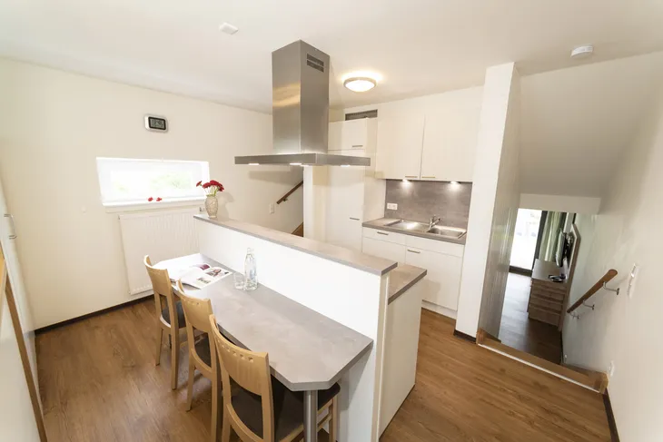 Moderne Küche mit Tresen und Holzstühlen in einem Ferienhaus.