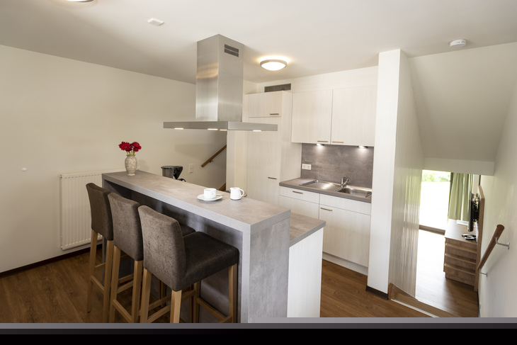 Moderne Küche in einem Ferienhaus mit Tresen und Barhockern.