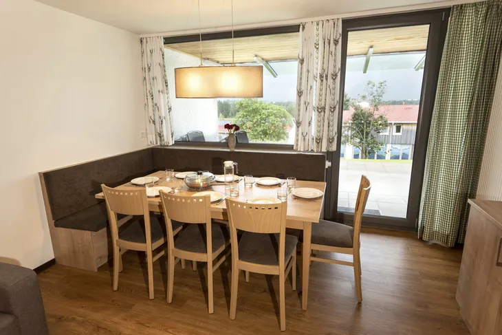 Essbereich in einem Ferienhaus mit Tisch, Stühlen und Fensterblick