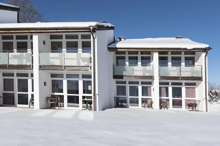 Ferienwohnung im Winter mit viel Schnee vor moderner Architektur in Inzell.