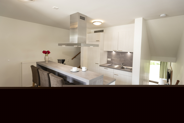 Moderne Küche in einem Ferienhaus mit Tresen und Barhockern.