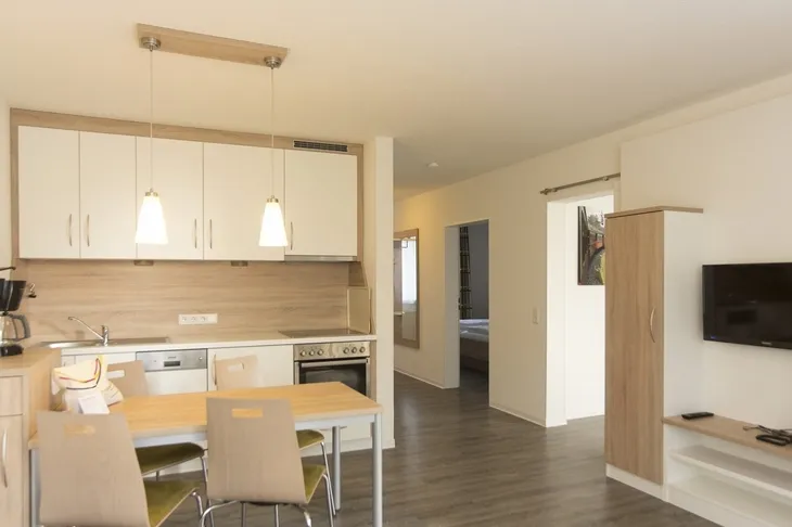 Moderne Wohnung mit offener Küche, Esstisch und Wohnbereich.