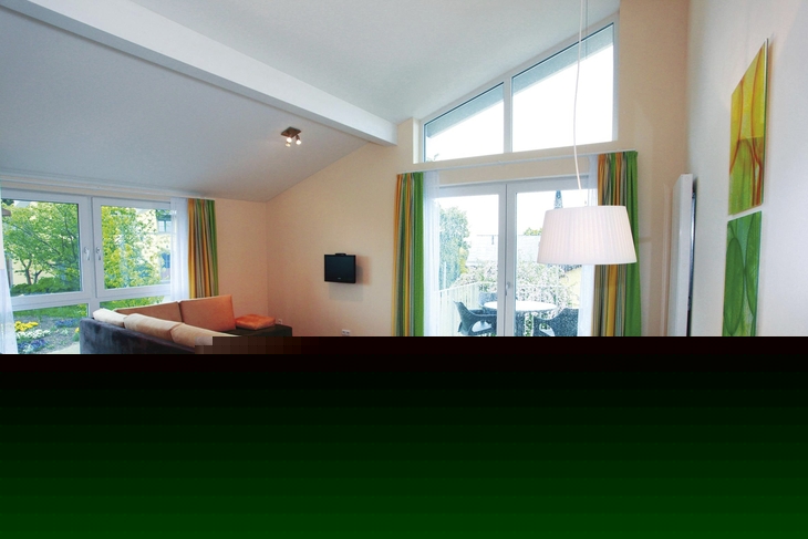 Helles Wohnzimmer mit Essbereich, Sofas, Tisch, großen Fenstern, modernen Möbeln.