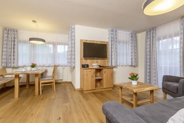 Helles Wohnzimmer mit Holzmöbeln und Esstisch, modern eingerichtet.