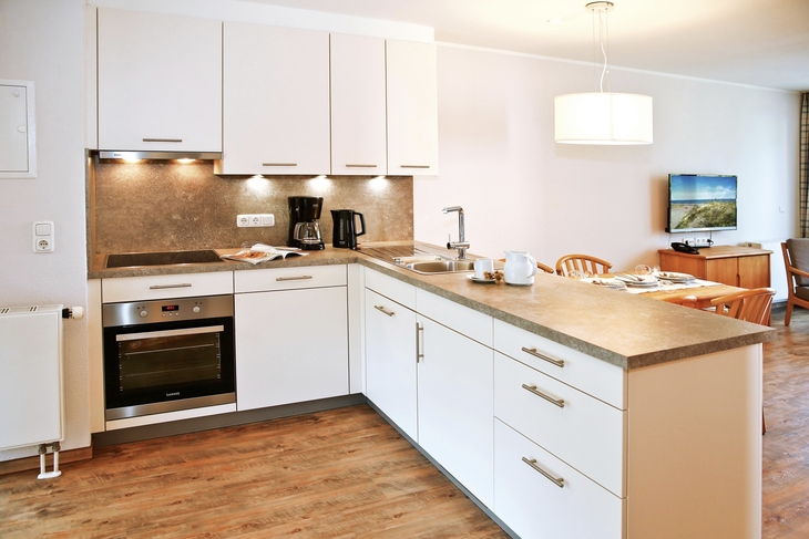 Moderne Küche mit weißer Einbauküche in einer Ferienwohnung.