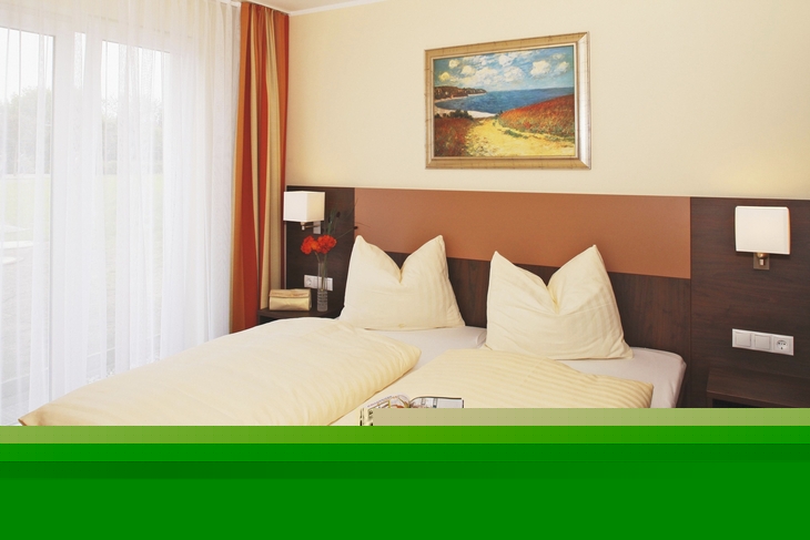 Doppelbett in modernem Hotelzimmer mit Bild an der Wand.