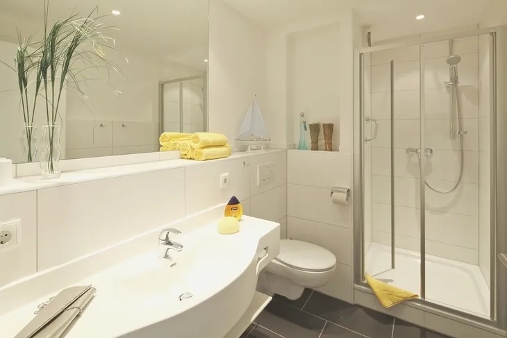 Modernes Badezimmer mit Dusche, Waschbecken und Dekorationen.