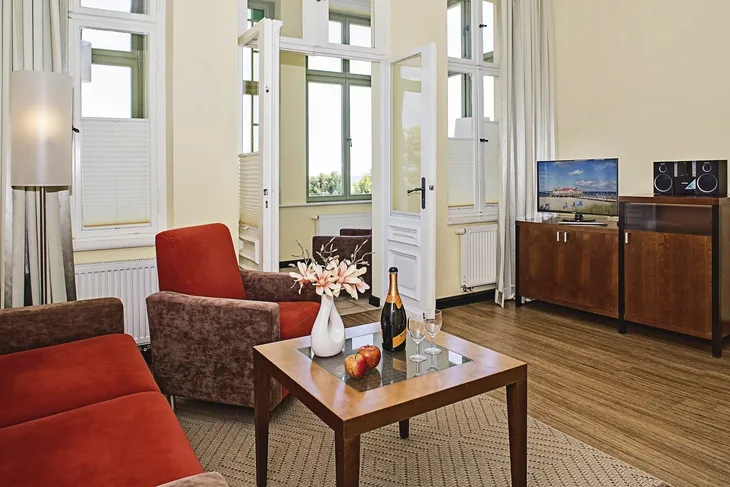 Wohnzimmer in Ferienanlage mit Sofas, Tisch, TV und Dekorationen.