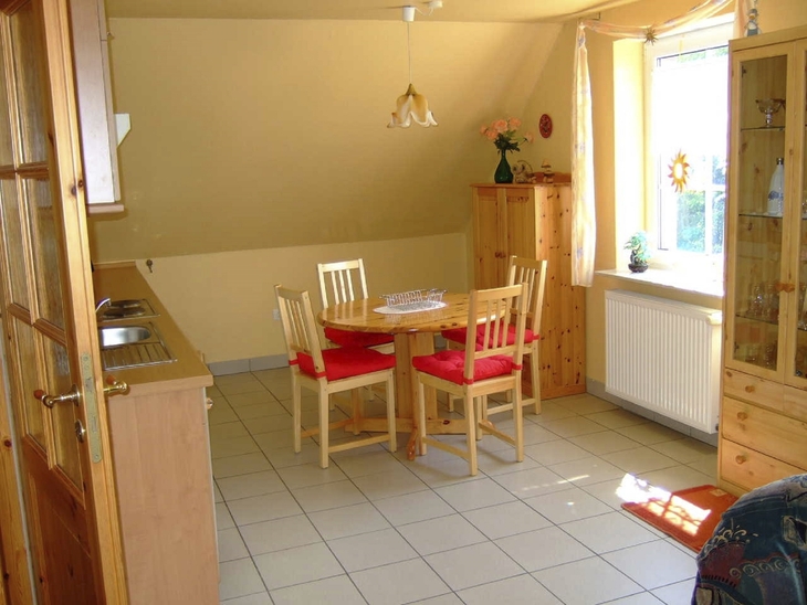 Essbereich mit Holzmöbeln und Esstisch am Fenster in heller Wohnung.