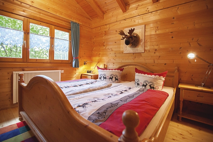 Holzinterior-Schlafzimmer mit Doppelbett und gemütlicher Atmosphäre.