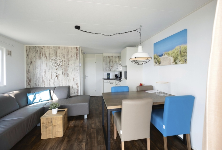 Wohnbereich mit Sofa, Esstisch, moderner Einrichtung und hellen Farben.