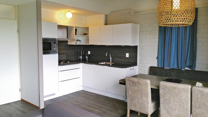 Moderne Küchenzeile mit Esstisch und Stühlen in einem Ferienhaus.