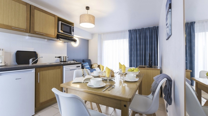 Essbereich und Küche in moderner Ferienwohnung mit Holzdekor.