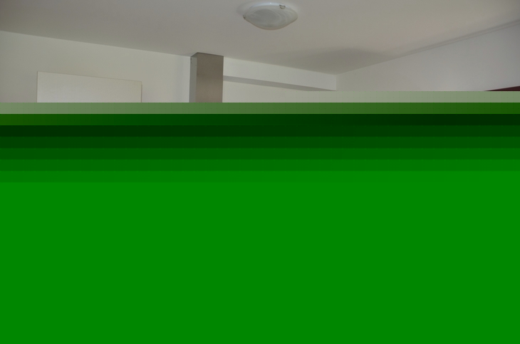 Moderne Küche mit Eckspüle, Ofen und Schränken in einer Ferienwohnung.