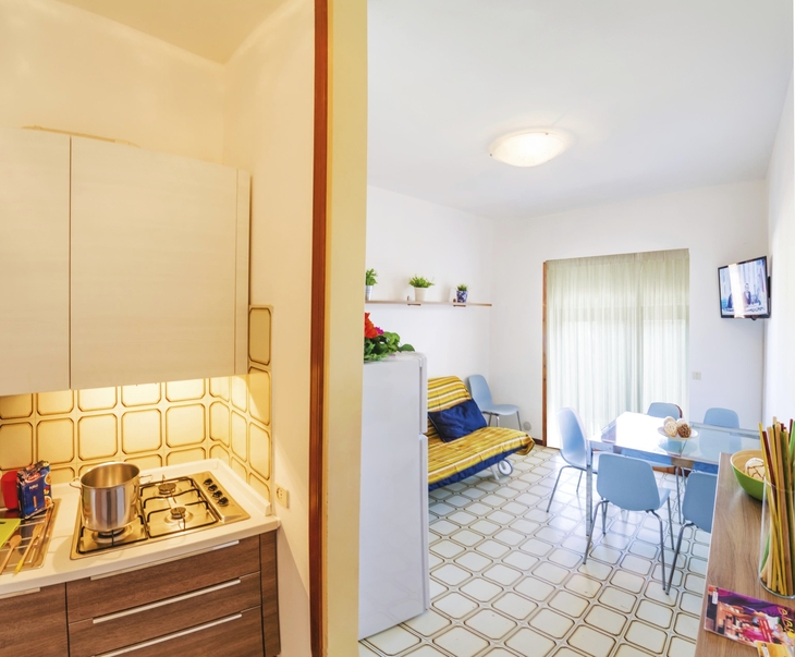 Küche und Essbereich in einer Ferienwohnung mit heller Einrichtung.