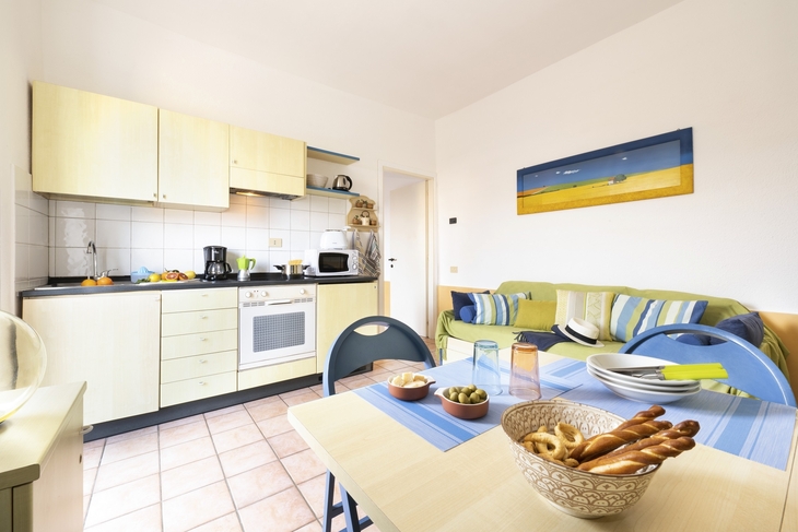 Helle Küche mit Esstisch, Sofa und moderner Ausstattung in einer Wohnung.