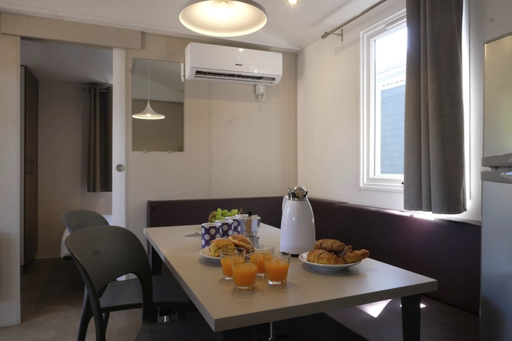 Tisch mit Frühstück, Saft und Croissants in einem gemütlichen Zimmer mit Klimaanlage.