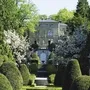 Villa Alwind in Lindau, umgeben von gepflegten Gärten und blühenden Bäumen.