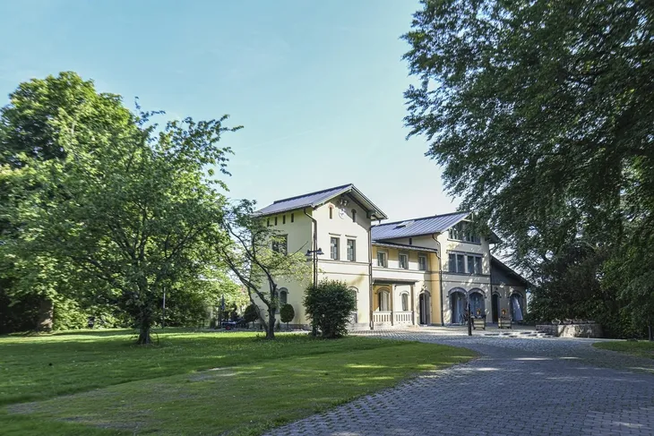 Historisches Gebäude mit Bäumen im Sommer.