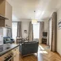Wohnzimmer mit Küche, Esstisch, Sofa und TV in einer hellen Wohnung.