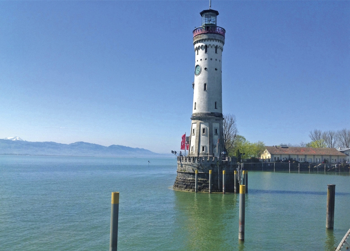 Leuchtturm auf dem Bodensee bei klarem Himmel und ruhigem Wasser.