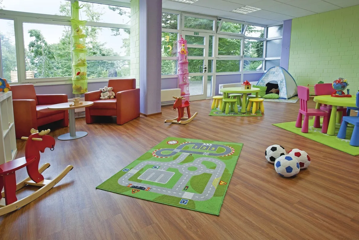 Helles Spielzimmer in der Ferienanlage Prüm mit Spielzeug, bunten Möbeln und großen Fenster.
