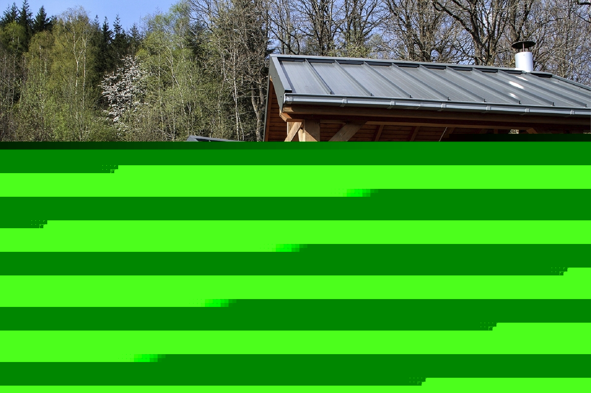 Drei überdachte Picknicktische im Freien in der Ferienanlage Prüm vor einem Waldgebiet.