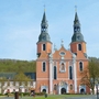 Basilika in Prüm mit zwei Türmen und barocker Fassade bei blauem Himmel.