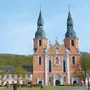 Basilika in Prüm mit zwei Türmen und barocker Fassade bei blauem Himmel.