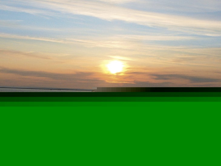 Sonnenuntergang über dem Meer bei Büsum mit Wolken und Wasserspiegelung
