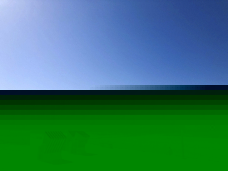 Weitläufiger Sandstrand mit Strandkörben und Meer unter blauem Himmel auf Norderney.