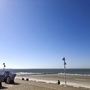 Weitläufiger Sandstrand mit Strandkörben und Meer unter blauem Himmel auf Norderney.