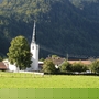 Kirche im Grünen vor bewaldeten Bergen im Ort Oberwössen.