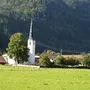 Kirche im Grünen vor bewaldeten Bergen im Ort Oberwössen.
