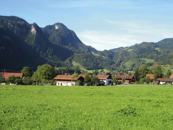 Landschaft von Oberwössen mit Bergen und Wiesen im Hintergrund.