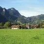Landschaft von Oberwössen mit Bergen und Wiesen im Hintergrund.